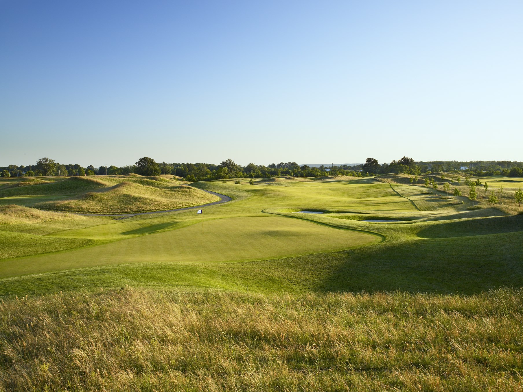 Image from behind hole 17 of Piper's Heath showing the green and fairway