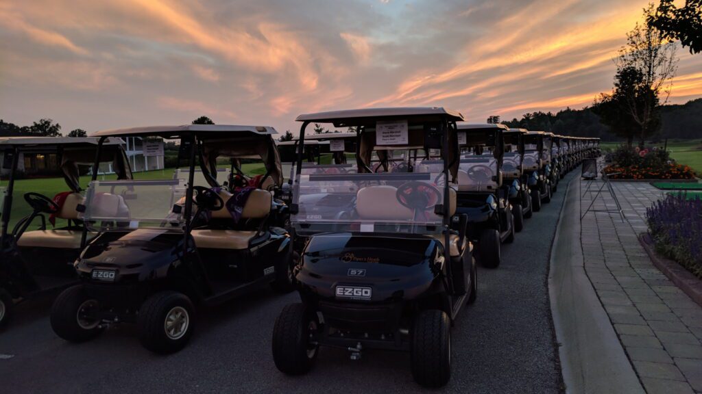Sunrise image of golf carts stage on piper's heath driving range for a tournament
