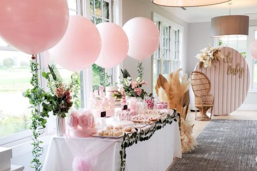 Piper's Heath banquet hall set up for baby shower with pink balloons and bright, white linens.